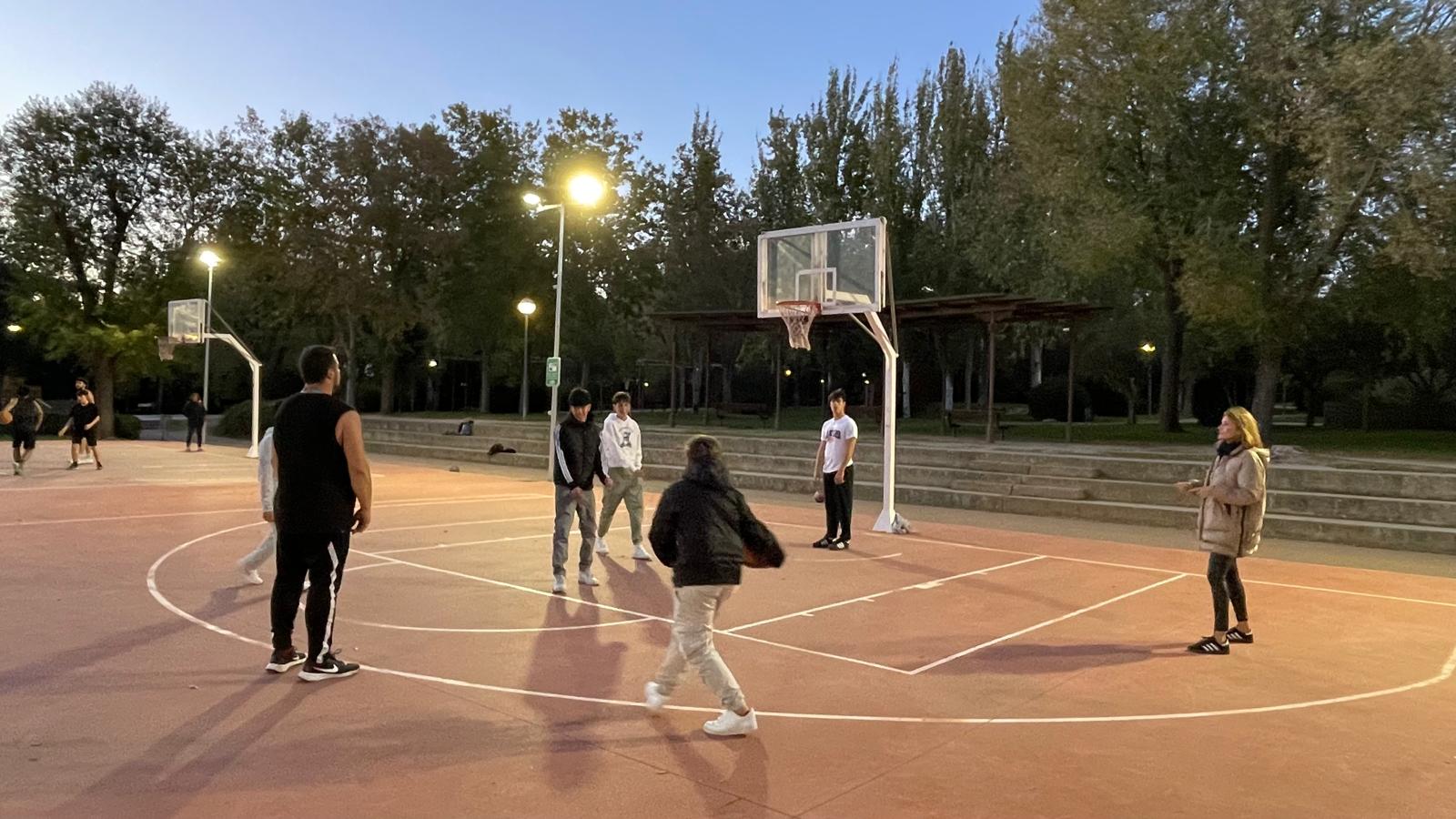 La concejala Almudena Parres junto a jóvenes jugando al baloncesto en las pistas deportivas del parque de los Jesuitas