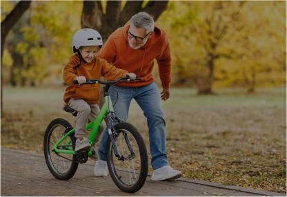 Padre ayudando a niño a ir en bicicleta