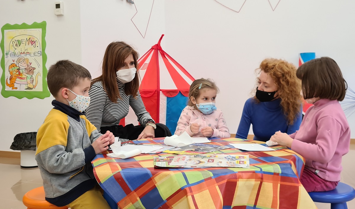 Almudena Parres y Ana Suarez junto a ninos de la ludoteca del Centro Victoria Adrados
