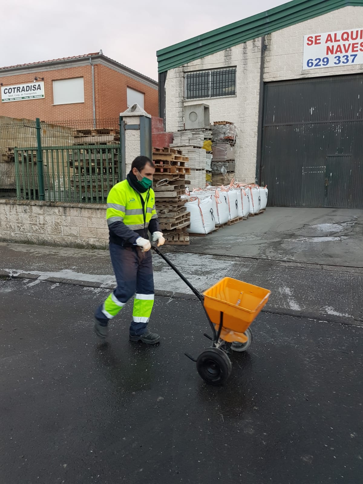 Un operario esparciendo sal por una de las calles de la ciudad